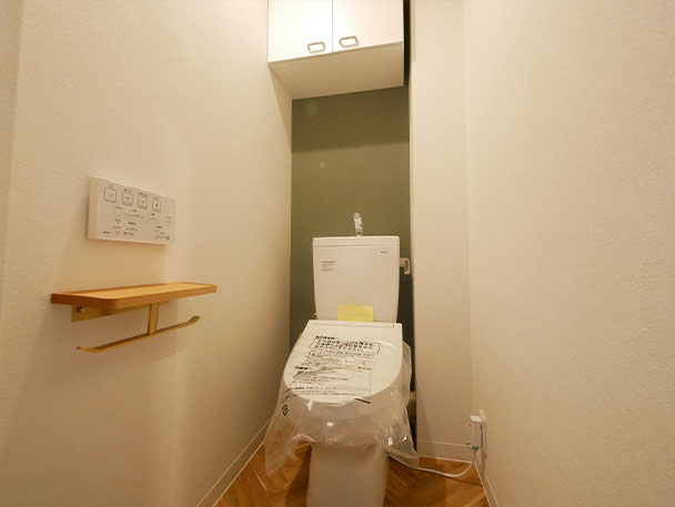 同じくグリーンのクロスがアクセントになったトイレは、洗面と同じヘリンボーンの床材を採用。